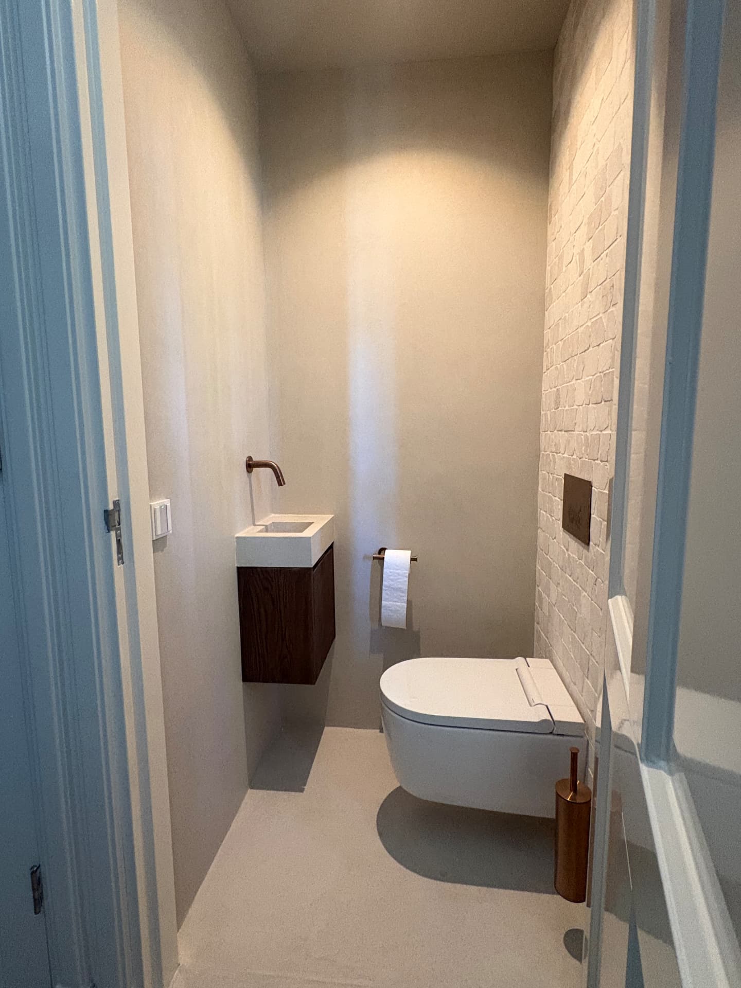Betonciré wanden in toilet met houten kastje — project in Enter en omgeving