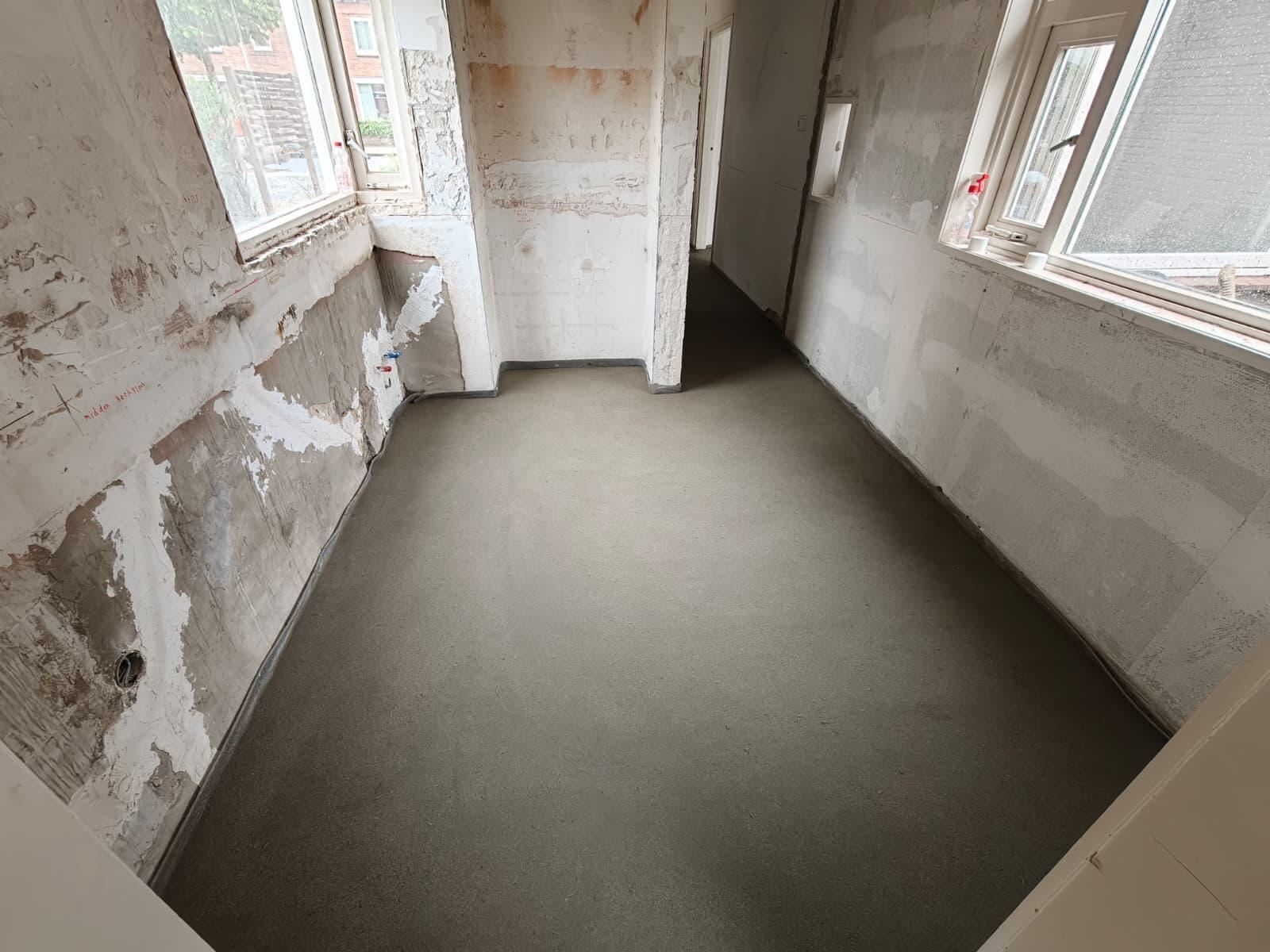 Machinaal gestorte cementdekvloer in een ruimte in aanbouw