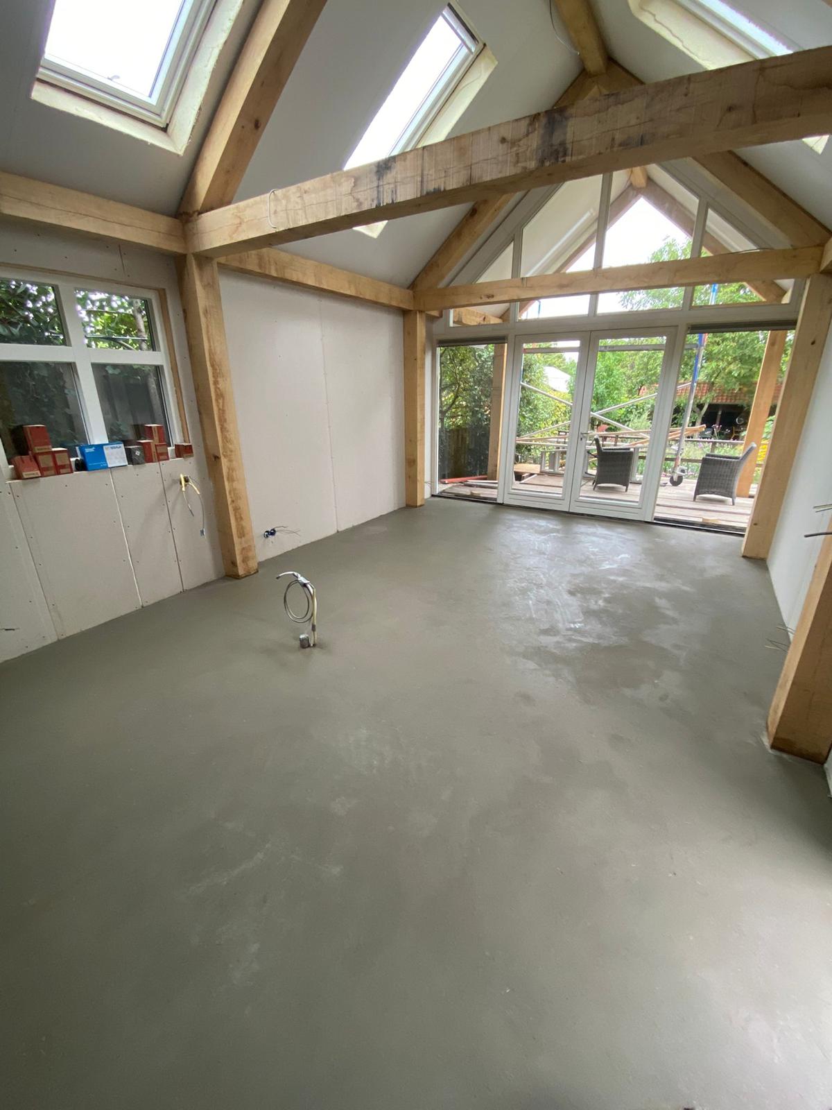 Cementdekvloer in een lichte aanbouw met veel glas